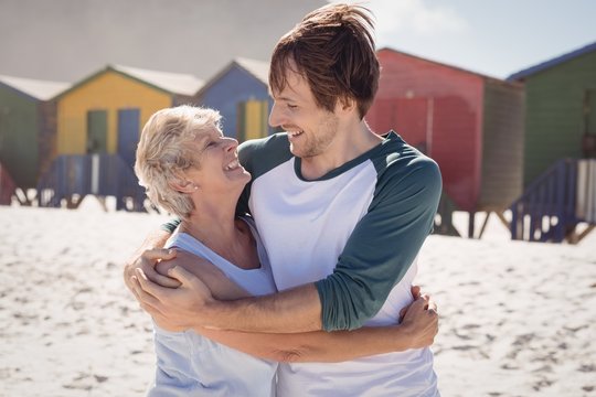 Happy Mother Embracing Her Son At Beach