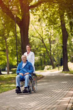 elderly man on wheelchair with nurse outdoor