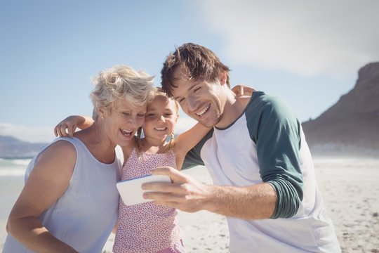 Happy multi-generated family taking selfie at beach