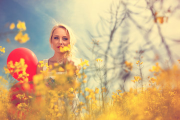 portrait of attractive blond female in yellow floral field