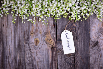 Gray wooden background with a paper tag with the inscription good morning