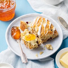 Scone with jam and butter on plate Blue background