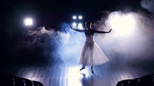 Dancing girl's silhouette performing on the stage. Slow motion. HD.