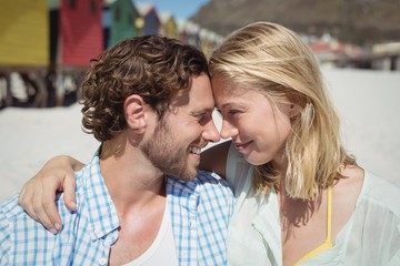 Happy couple looking face to face at beach