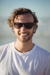 Portrait of smiling man wearing sunglasses at beach