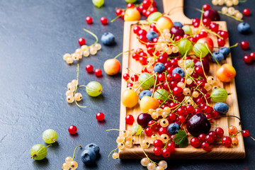 Naklejka na ściany i meble Fresh berries on wooden cutting board. Copy space