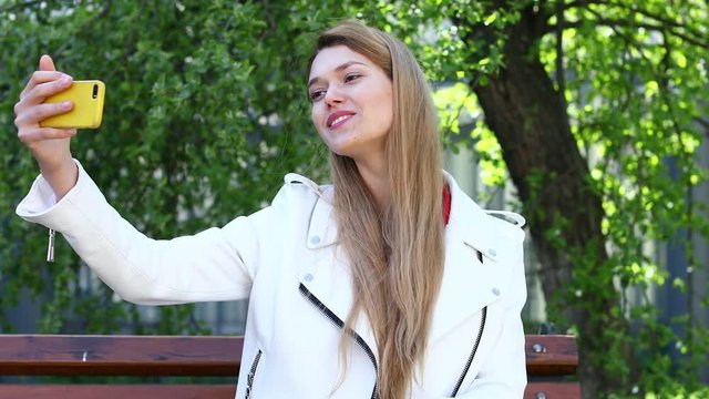 Video conference. Young beautiful blonde woman communicates on cellphone