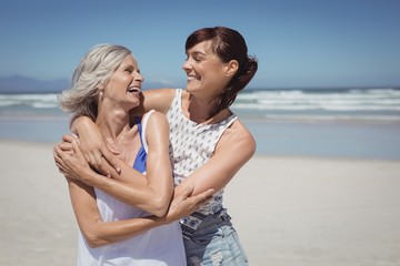 Happy woman with her mother standing at beach