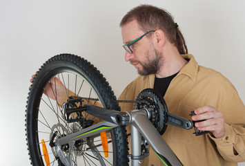 Fototapeta na wymiar Bearded caucasian man repairing the mtb bicycle