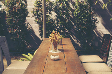 dry yellow flower on table in the cafe, vintage filter image