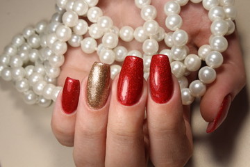 Manicure nails extensively bright red and gold color