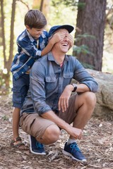 Playful boy covering fathers eyes while hiking 