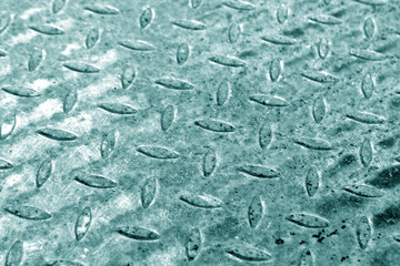Close-up of cyan metal floor pattern with blur effect.