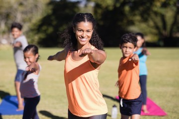 Portrait of trainer teaching Virabhadrasana II pose