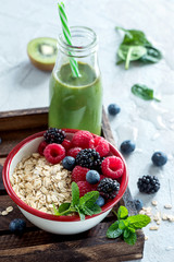Muesli with berries and green smoothie bottle, fresh healthy breakfast, vegan, diet and detox concept,  healthy lifestyle