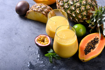 Healthy smoothie with tropical fruits, pineapple, papaya and passion fruit, exotic vitamin drink