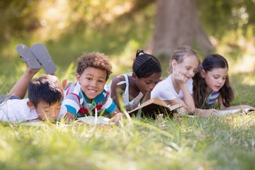 Group of friends reading book at campsite