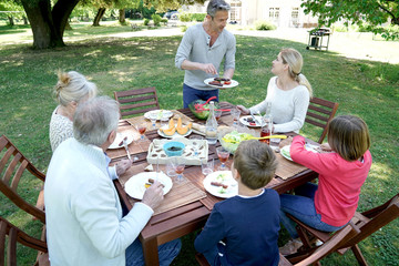 Family having summer lunch in garden