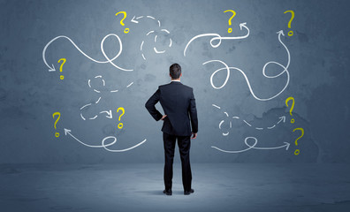 Unsure businessman with question marks