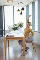 Executive stretching her hands while working at desk