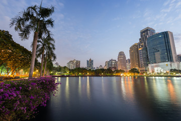 Scenic view of the Benjakiti (Benjakitti) Park and lit buildings in Bangkok, Thailand, in the evening.