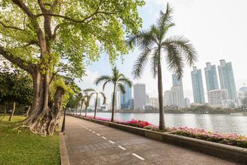 Jogging path at the Benjakiti (Benjakitti) Park and modern skyscrapers in Bangkok, Thailand. © tuomaslehtinen