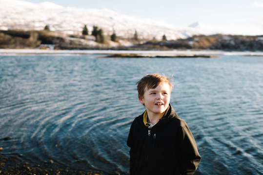 Boy standing near lake