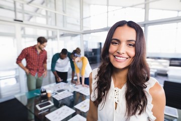 Fototapeta premium Portrait of businesswoman with colleagues in background