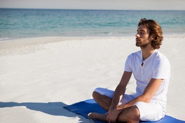 Fototapeta na wymiar Man with eyes closed meditating at beach