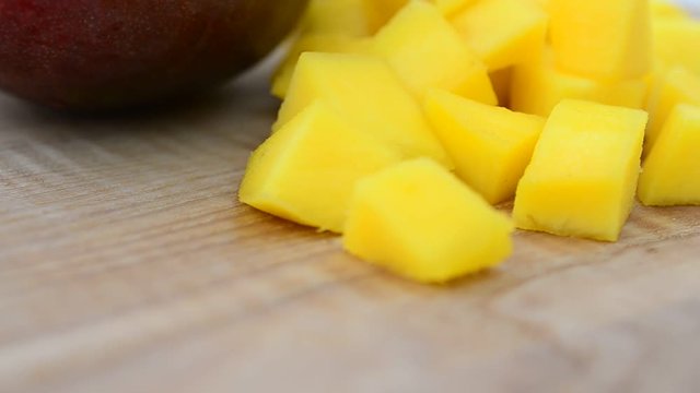Mango pieces on a wooden board.