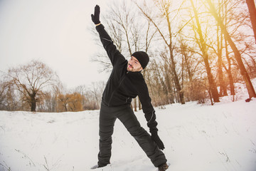 Fitness, sport, exercising, training and lifestyle concept - young man exercising in winter park
