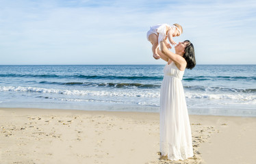 Fototapeta na wymiar Mother and her baby girl on the sandy beach