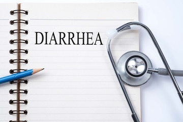 Stethoscope on notebook and pencil with diarrhea words as medical concept.