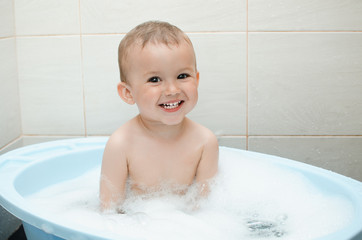 Happy baby boy taking a bath