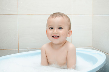 Happy baby boy taking a bath