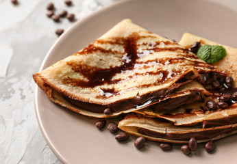 Plate with delicious pancakes and chocolate sauce, closeup