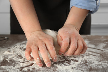 Obraz na płótnie Canvas Female chef kneading dough in kitchen