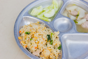 closeup stainless tray with fried rice and soup, shallow depth of field.
