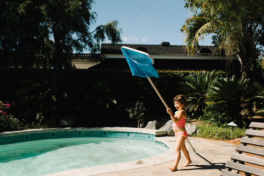 Girl walking next to swimming pool with net