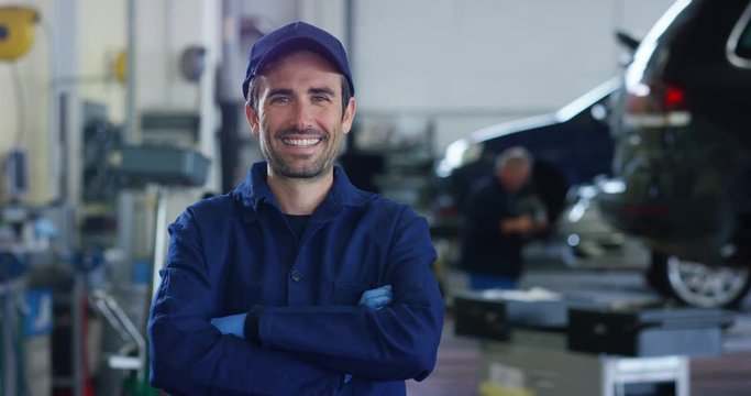 Portrait of a young beautiful car mechanic in a car workshop, in the background of service. Concept: repair of machines, fault diagnosis, repair specialist, technical maintenance and on-board computer