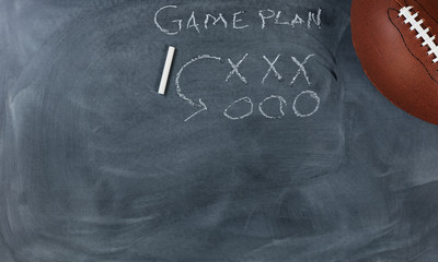 American football with game plan on chalkboard setting for strategy 