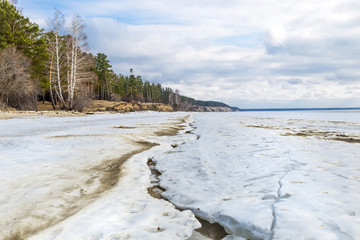The coast of the Ob river with melting ice