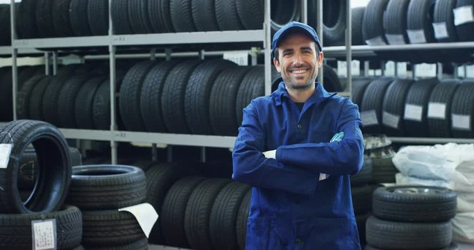 Specialist tire fitting in the car service, checks the tire and rubber tread for safety. Concept: repair of machines, fault diagnosis, repair specialist, technical maintenance and on-board computer.