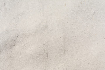 Texture of an embossed antique concrete wall with cracks and a ruined plaster protective layer, abstract background