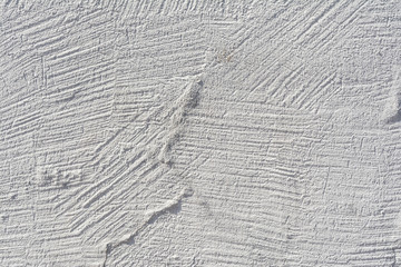 Texture of an embossed antique concrete wall with cracks and a ruined plaster protective layer, abstract background