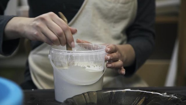 Close up of woman s hands stirring self made glue in a jar. Locked down real time close up shot