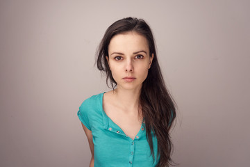 Fototapeta premium brunette in a blue shirt on a gray background