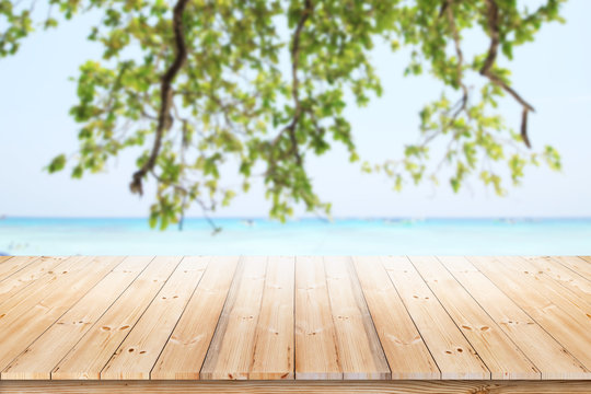 Wooden houses by the sea Wood table top with blurred nature scene tropical beach and blue sky, holiday background concept - can be used for display or montage your products.