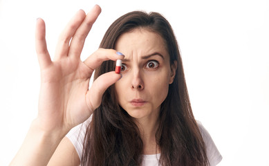 interested woman looks at pill