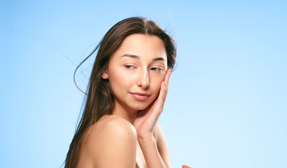 naked woman on a blue background, turn around half a turn